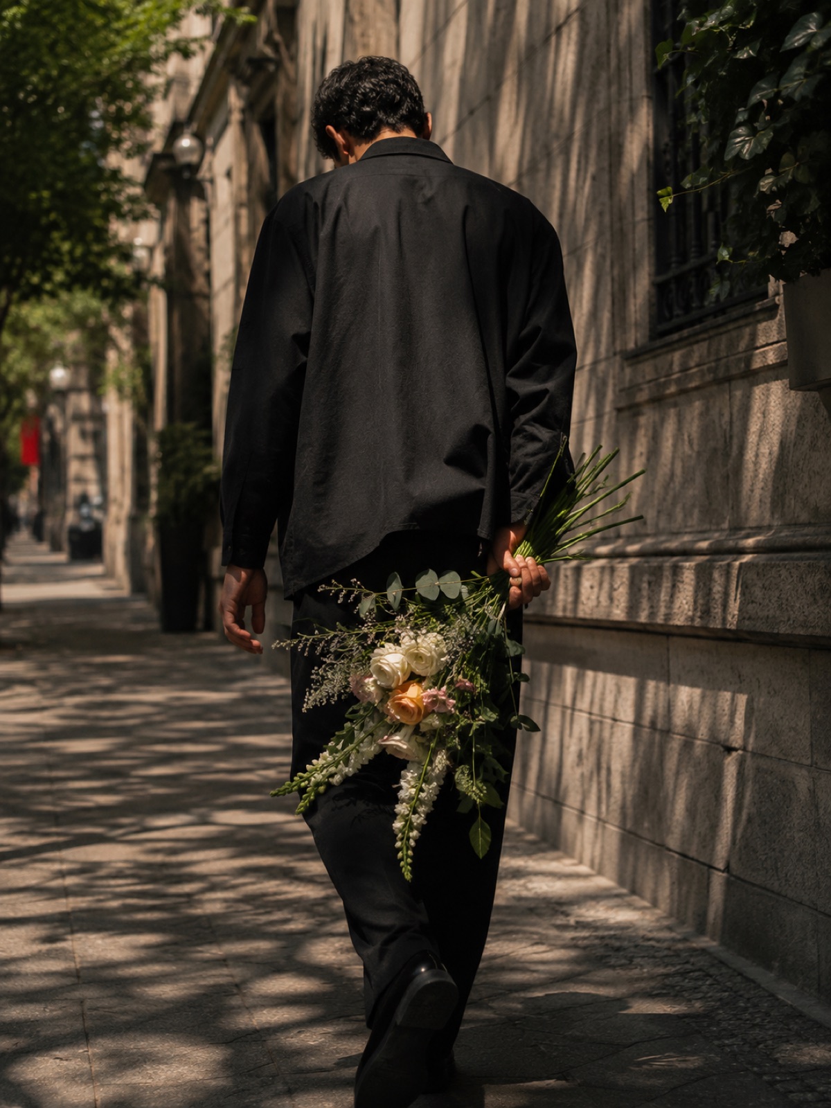Persona caminando por una calle de CDMX con un ramo de flores en la mano